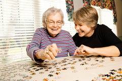 volunteer working a puzzle with a resident