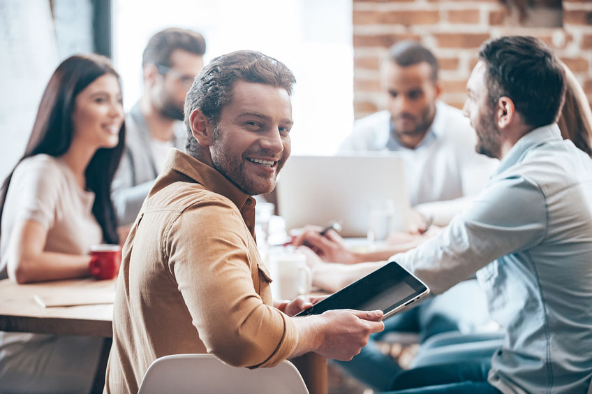 group of people sitting around a table, chatting