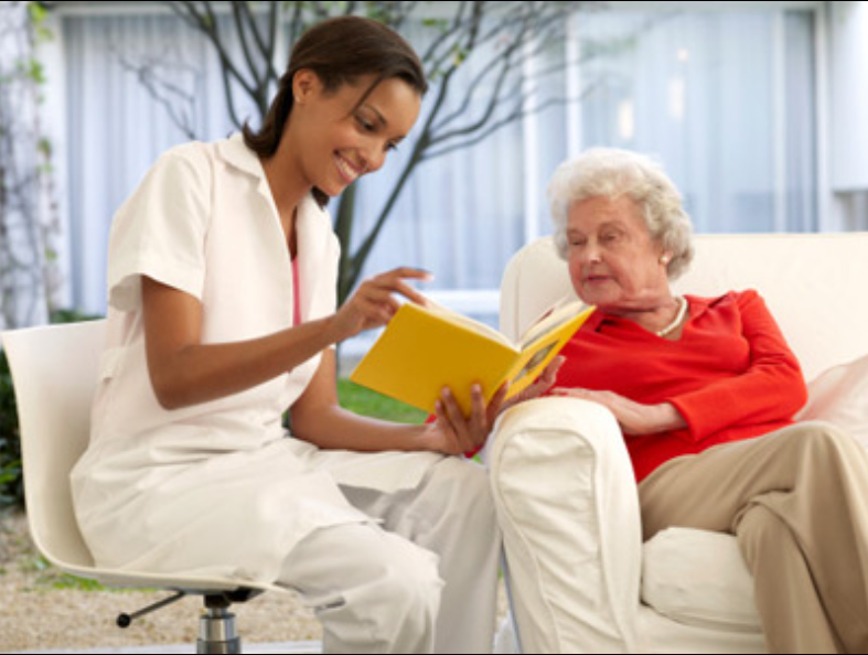 A volunteer reading to an older woman